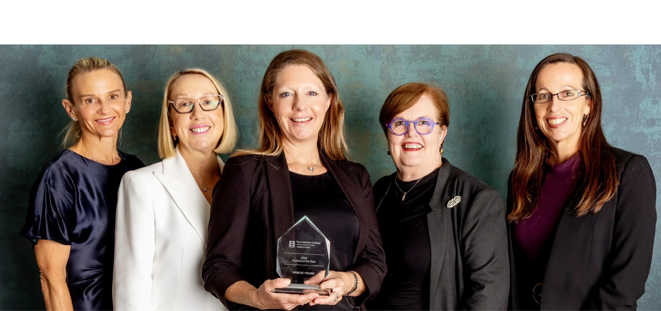 Five people dressed in business clothing stand together as a group for the camera.