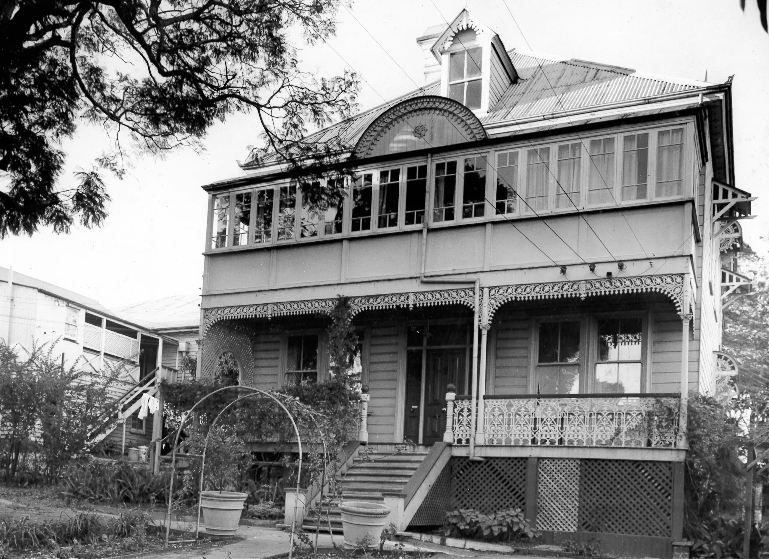 A black and white photo of a two-storey building with a cottage-style facade.