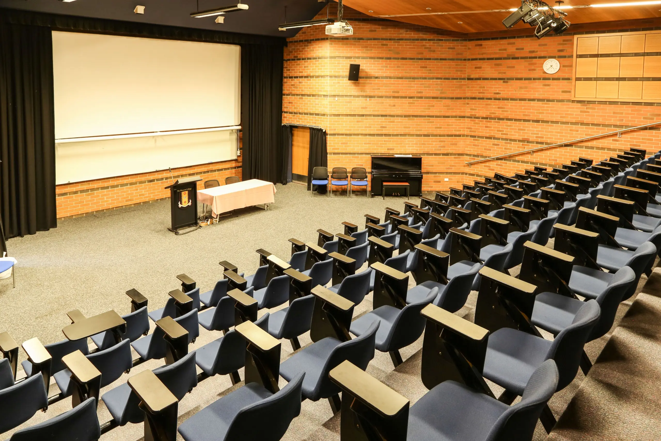 The inside of an auditorium, with tiered chairs like in a lecture theatre.