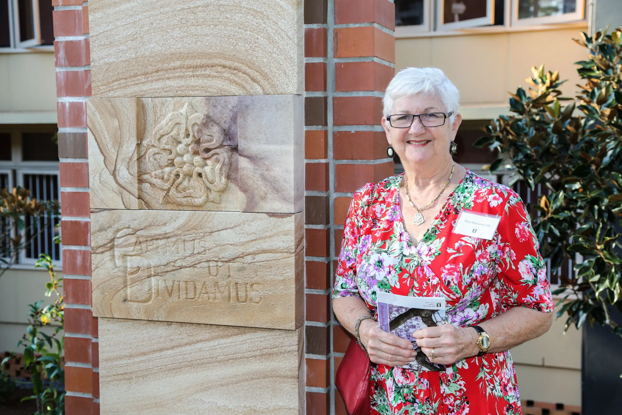 An artist stands with her sandstone sculpture art.
