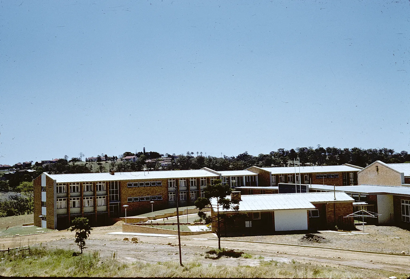 A colour photo of buildings in the foreground and blue sky in the background.